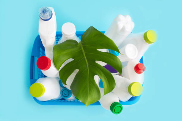 istock Used Plastic bottles with caps and green leaf in basket for recycling. 1287288389