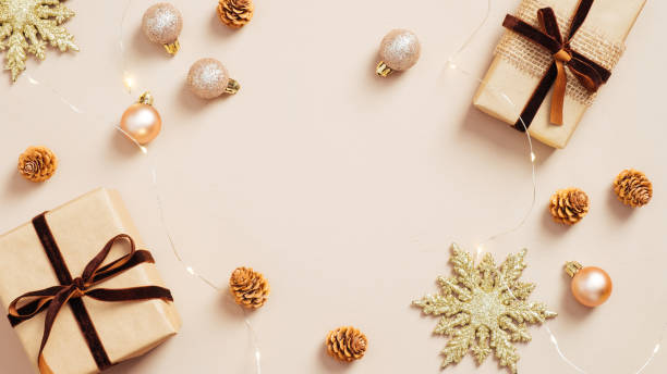 istock Modern Christmas decorations and gift boxes on pastel beige background. Flat lay, top view. 1287290604