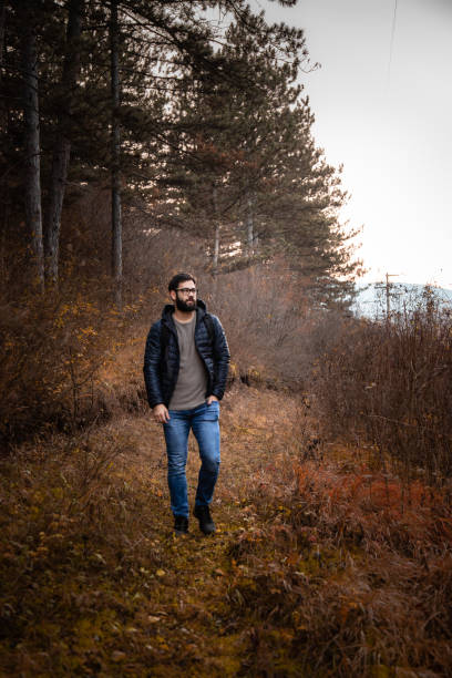 istock Beard man walking through forest Stock Photo 1287290760