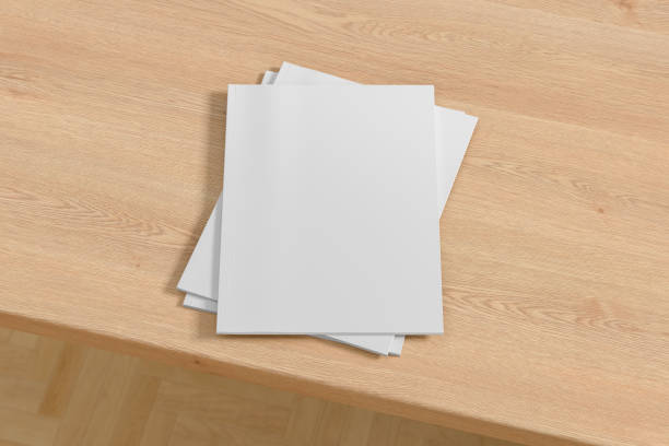 istock Vertical white magazine or brochure stack mockup on wooden table 1287292027