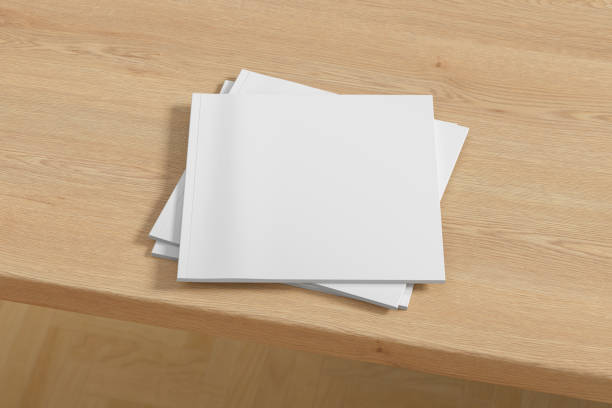 istock Square white magazine or brochure stack mockup on wooden table. 1287292080
