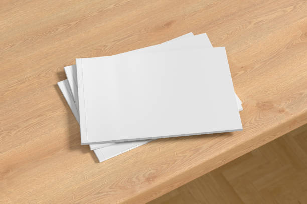 istock Horizontal or landscape white magazine or brochure stack mockup on wooden table 1287292293
