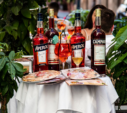 Samples of pizzas, Campari, Aperol on a table outside a restaurant in Rome, Italy