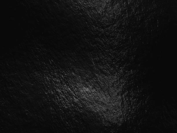 istock Black foil background with highlights and uneven texture 1287294046