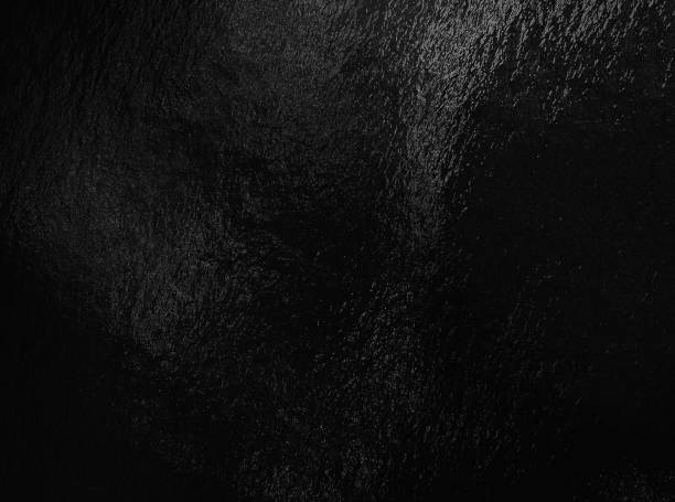 istock Black foil background with highlights and uneven texture 1287294069