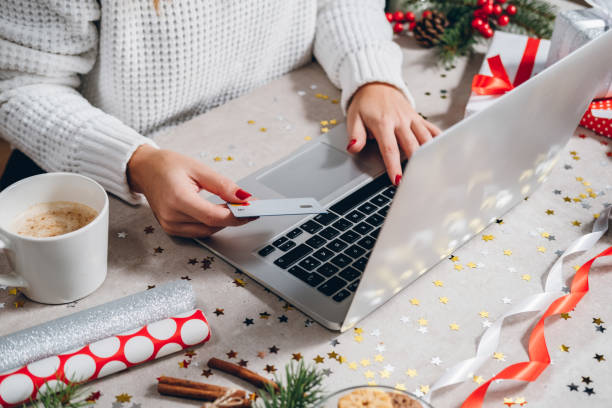 frau macht weihnachtseinkäufe online mit laptop und kreditkarte - buche samen stock-fotos und bilder