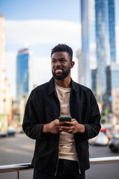 istock Young man walking using cellphone in the city street 1287296013