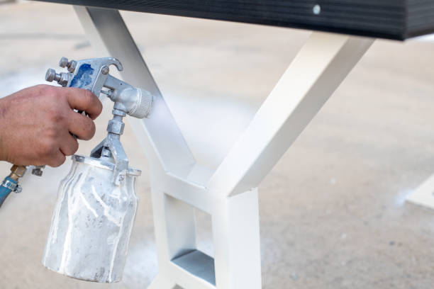 istock man painting a table with white spray paint. 1287296121