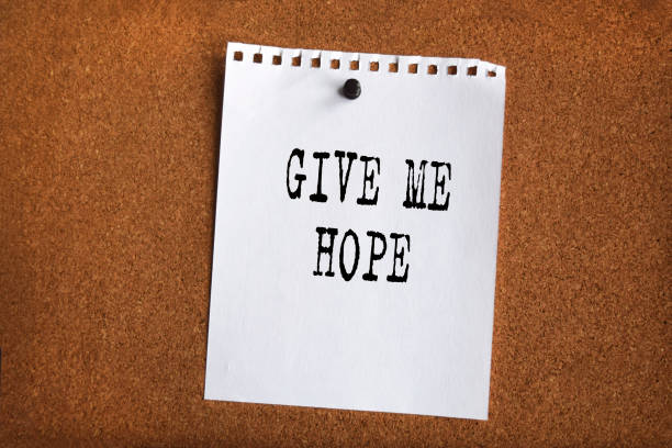 istock Paper note written with GIVE ME HOPE inscription on cork board 1287297935