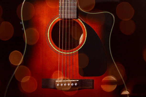 istock Acoustic guitar. Part of the case and strings on a black background. 1287298513