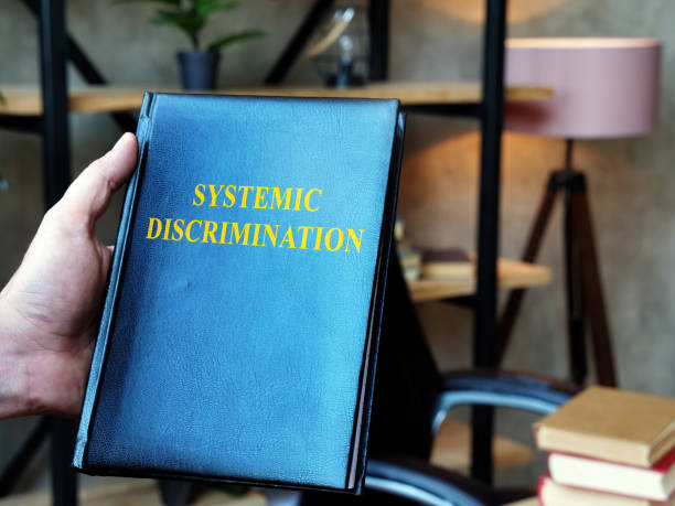 istock Lawyer holds Systemic Discrimination book in the office. 1287298776