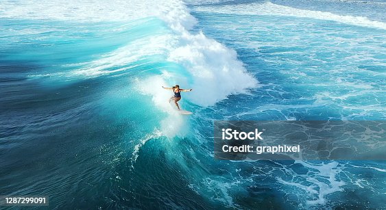 istock Surfer woman riding on the blue ocean 1287299091