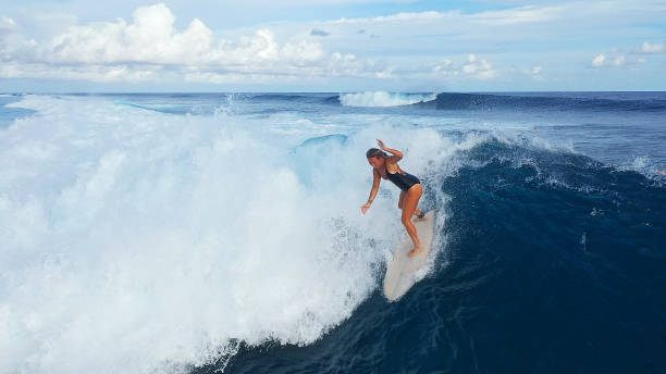 istock Surfer woman riding on the blue ocean 1287299411