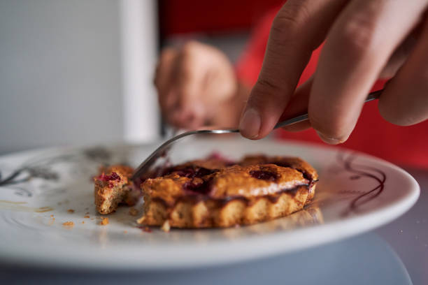 istock Man cutting a baked muffin with raspberries with knife and fork 1287301967