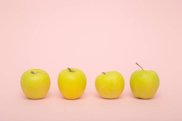 istock Golden delicious apples on rose background 1287302160