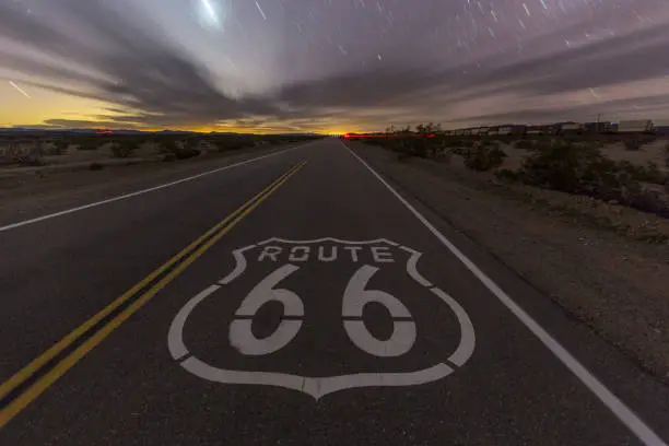 Historic Route 66 highway pavement sign late at night in the California Mojave desert.