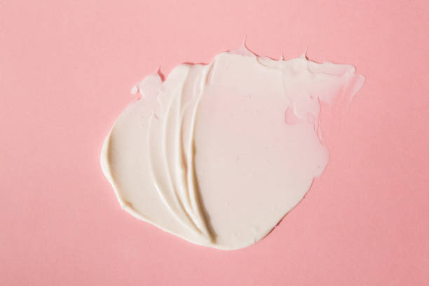 istock A light cream smear on a flat lay. Smear, mask, cream, light, face, pink background. 1287303635