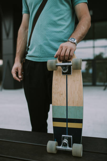 istock Casually dressed man holding his skateboard in front of his office. 1287304808