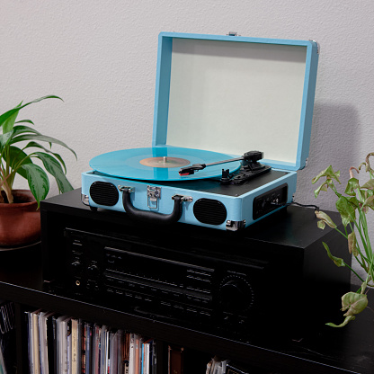 Blue Record player and blue colored vinyl disc playing a happy song.