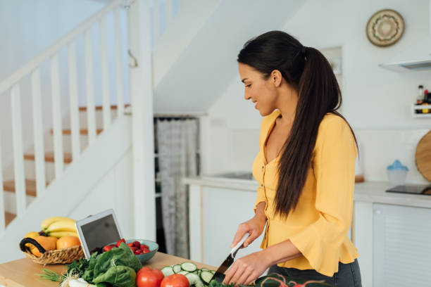 istock Attractive young woman preparing food in her kitchen 1287310061