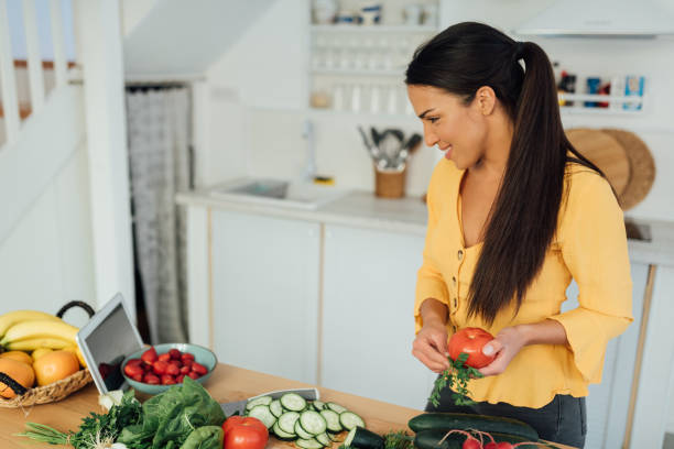 istock Attractive young woman preparing food in her kitchen 1287310096