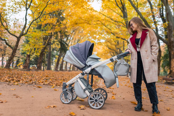 istock Joyful mom smiles to her baby in a stroller 1287310246