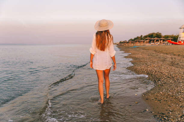 istock Woman walking on the sea beach 1287310595