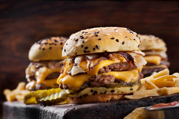 double cheese burger sliders with fried onions, pickles on a brioche sesame seed buns with fries - sesame bun american culture cheddar imagens e fotografias de stock