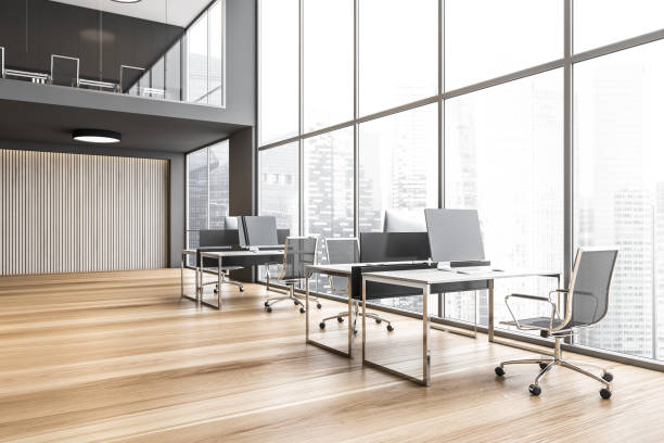 istock Tables with computers near big window, skyscrapers view open space lobby 1287311907