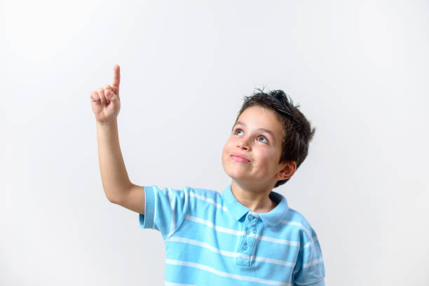 istock A boy in a blue T-shirt with a brooding face raised his finger up. 1287312516