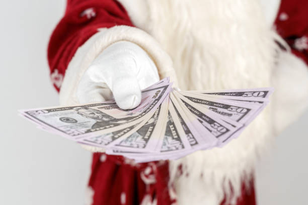 istock Santa Claus holds money in his hands. Isolated on light background 1287316587