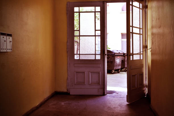 large doors with windows staircase tenement house corridor and litter bins containers
