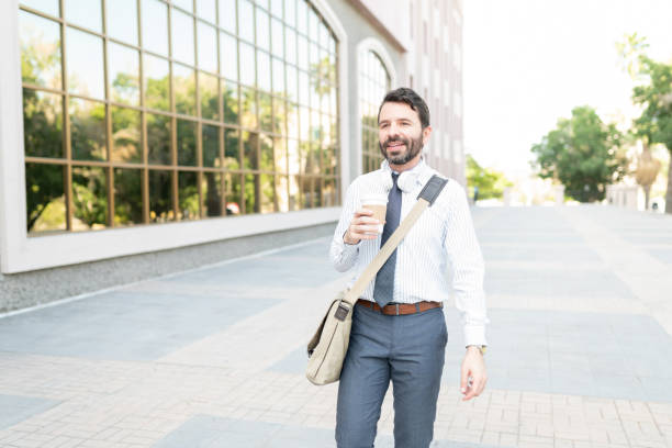 istock Happy businessman walking to the office with a coffee 1287317767