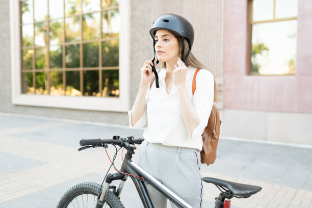 istock Active professional female worker fixing his helmet on top of a bicycle 1287317840