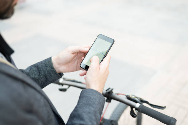 istock Man in his 30s with a bycicle looking a the gps app on his smartphone 1287317872