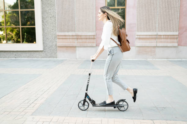 istock Caucasian female worker riding an eco-friendly scooter 1287318473