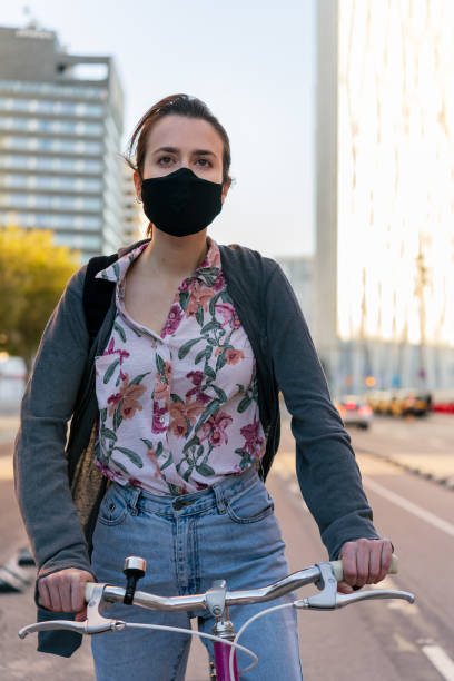 istock girl with protective mask riding bicycle at city 1287327701