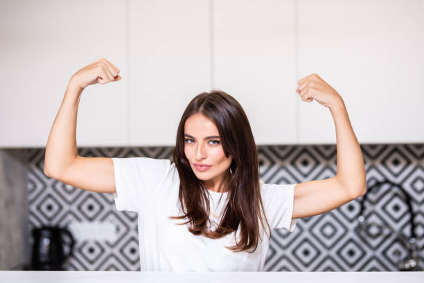 istock Young woman flexing muscles in the kitchen at home 1287327850