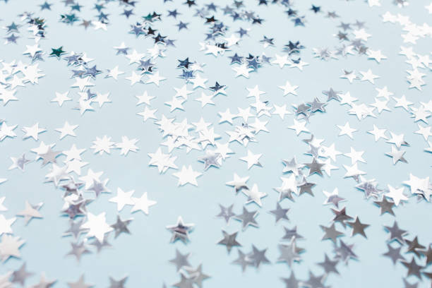 istock Silver foil confetti stars on blue background 1287332095