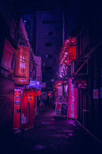 Rainy night scene with bright glowing signs in street in Shinjuku Tokyo Japan
