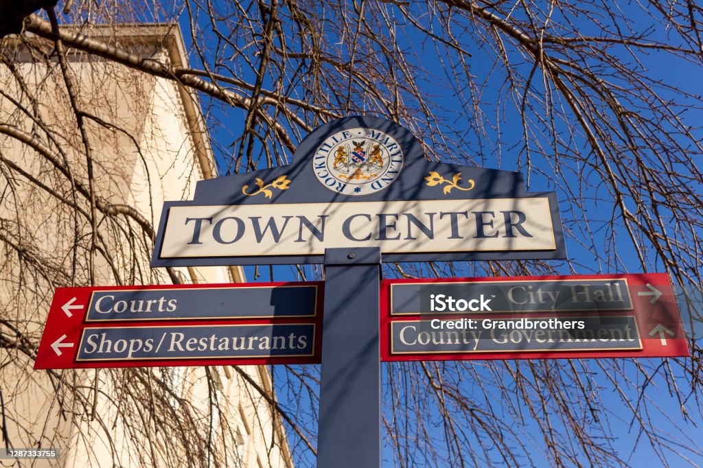 sign post located in the town center of Rockville, Maryland showing directions of shops, courts and government offices Close up, isolated image of a sign post located in the town center of Rockville, Maryland showing directions of shops, courts and government offices. Rockville is the county seat of Montgomery County. Maryland - US State Stock Photo