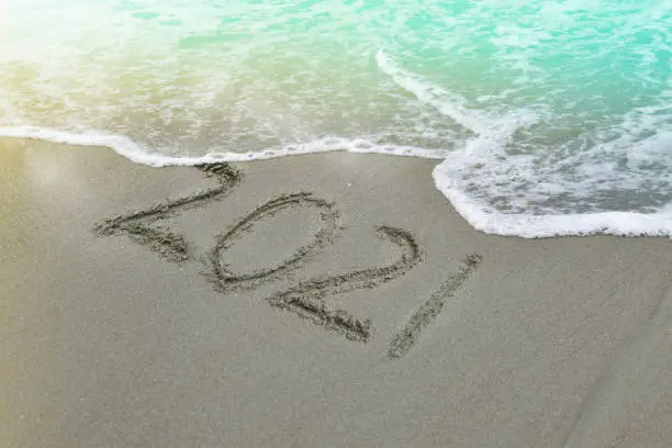 Photo of Happy New Year 2021 text on the beach