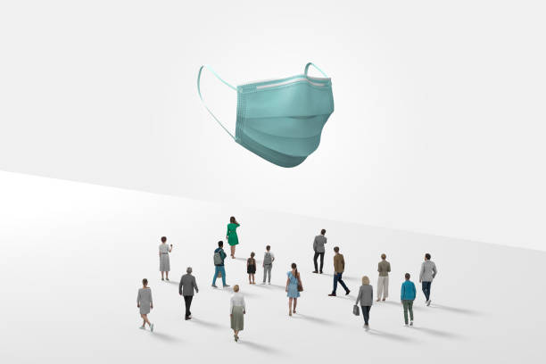 istock Surgical Mask Floating In White Space Above Crowd Of Mini Figurines 1287337067