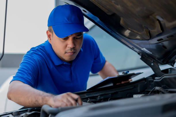 istock A young Asian auto mechanic opens the bonnet. To check for engine damage And perform professional maintenance. He wearing blue uniform. 1287344373