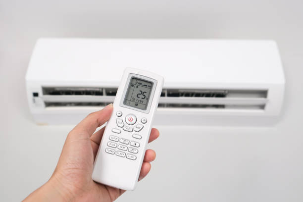 istock Man's hand using remote control open The air conditioner is cooled to 25 degrees Celsius in his bedroom. Health concepts and energy savings 1287344554