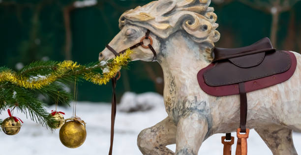 istock Wooden horse by the tree decorated with balls 1287351202