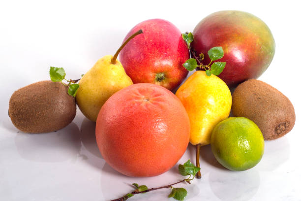 Fruit platter, mango, pear, lime, kiwi, grapefruit, green leaves on twigs, close-up, text space, wallpaper, postcard, background, advertising