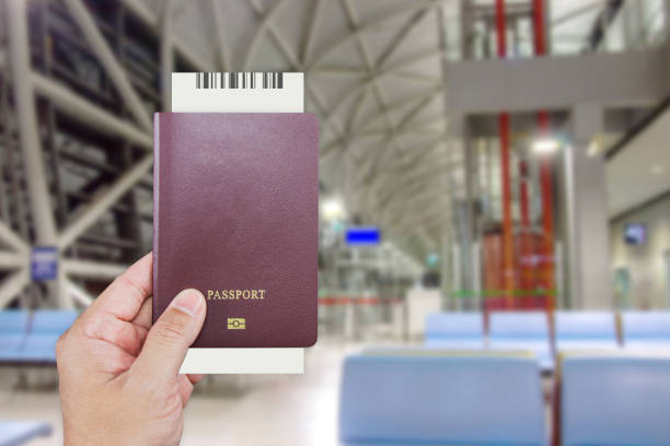 istock Man's hand holding international passport while wait at front the counter for check-in inside the Kansai International Airport (KIX) is one of Japan most important commercial airports. 1287357427