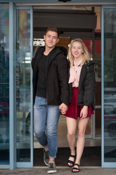 istock Happy young couple leaving shopping mall 1287357628