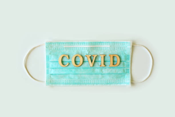 istock Medical shielding mask with word COVID isolated over white background. 1287359626